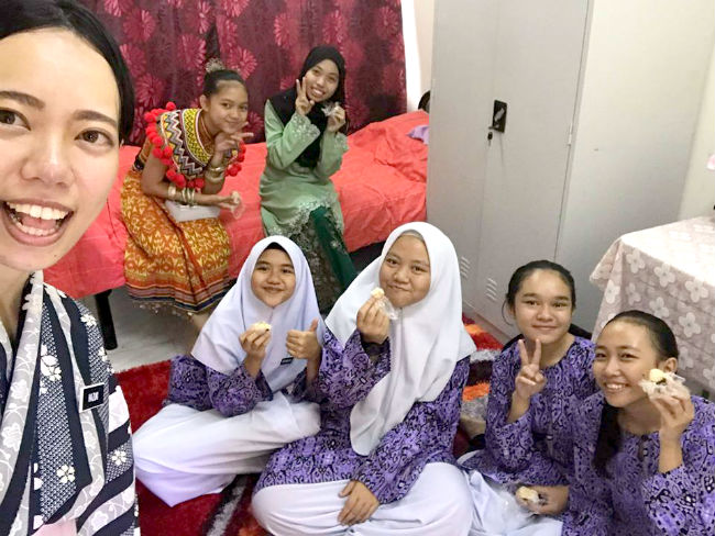 日本語パートナーズ マレーシア サラワク州 飯島さんのオープンハウスを楽しみに列をなして待ってくれた女子生徒たちと一緒に撮った写真 イバン族の民族衣装を身に着けた女子生徒も一緒にいる