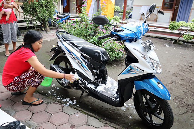 バイクを洗車する女性の写真