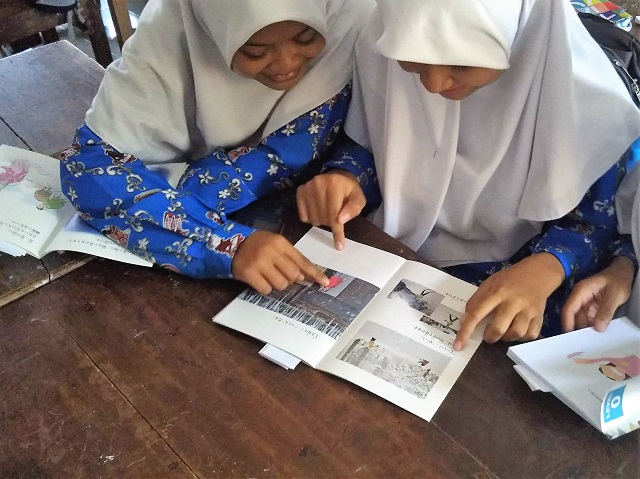 クラスメイトとにぎやかに本を読む生徒の写真