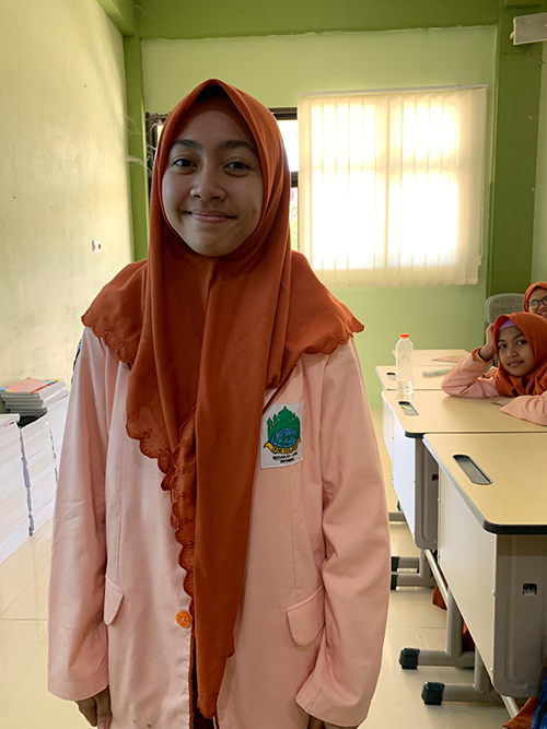 オレンジ色のヒジャブを着た女子生徒の写真