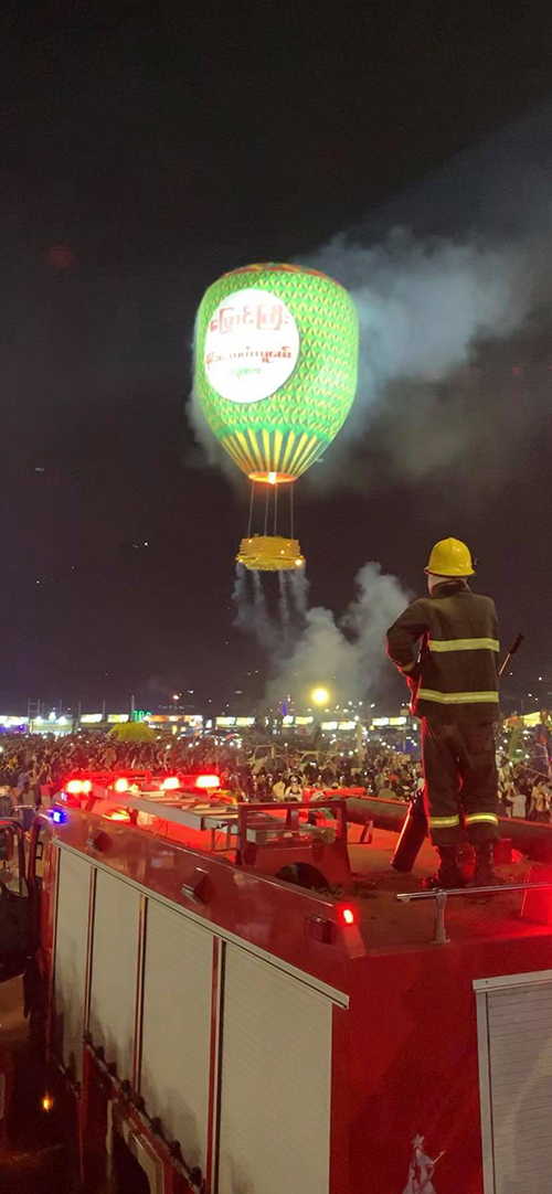 花火がくくりつけられた気球を見守る消防士さんの写真